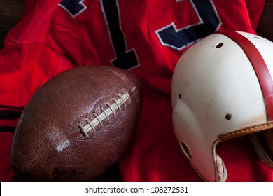 A Group Of Vintage, Antique American Football Equipment Including A Jersey, Football And A Helmet