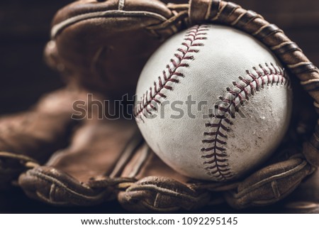 A group of vintage baseball equipment, bats, gloves, baseballs on wooden background