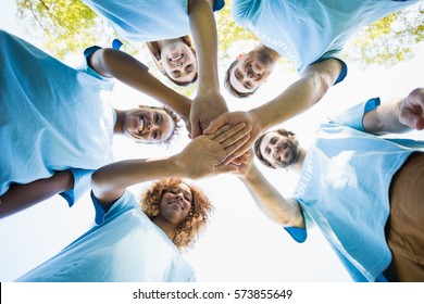 Group of volunteer forming huddles in park - Shutterstock ID 573855649