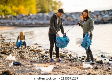 Group of volunteers cleaning beach on sunny day - Powered by Shutterstock