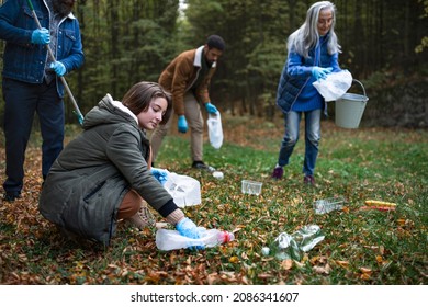 Group of volunteers cleaning up forest from waste, community service concept - Powered by Shutterstock