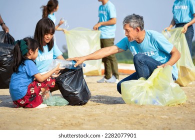 group of volunteers cleanup at the sand beach and adult help children collect and separate plastic bottle for recycle, concept of environmental issue and conservation,  campaign, awareness, support  - Powered by Shutterstock