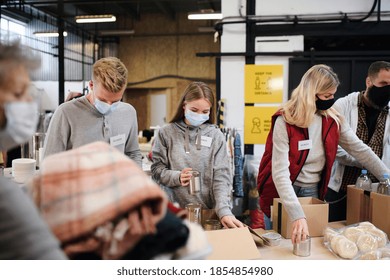 Group Of Volunteers In Community Charity Donation Center, Food Bank And Coronavirus Concept.