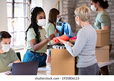 Group Of Volunteers With Face Mask Working In Community Charity Donation Center.