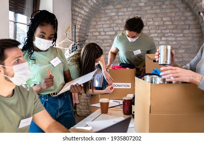 Group Of Volunteers With Face Mask Working In Community Charity Donation Center.