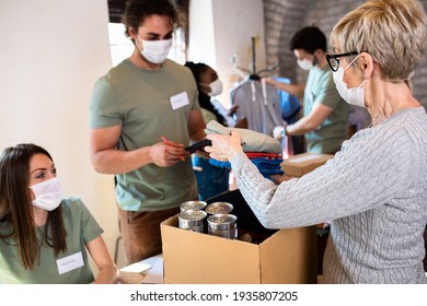 Group Of Volunteers With Face Mask Working In Community Charity Donation Center.