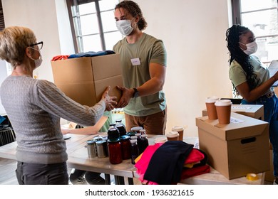 Group Of Volunteers With Face Mask Working In Community Charity Donation Center.