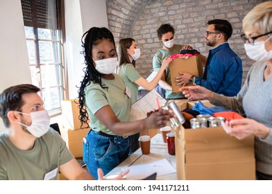 Group Of Volunteers With Face Mask Working In Community Charity Donation Center.