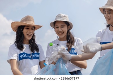 Group of volunteers holding rubbish bags collecting plastic bottles in bags. clean up garbage in tourist attractions. Conservation and care cleanliness in nature.