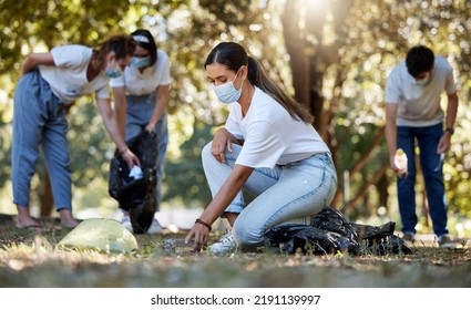 Group Of Volunteers Picking Up, Cleaning And Reducing Pollution In A Public Nature Park Together. Diverse Community Wearing Face Masks To Protect From Disease, Collecting Dirt And Doing Cleanup