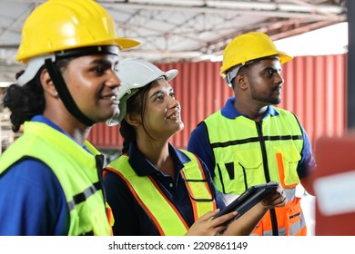 Group Of Warehouse Workers With Hardhats And Reflective Jackets Standing And Raising Hands Celebrate Successful Together Or Completed Deal Commitment At Retail Warehouse Logistics, Distribution Centre