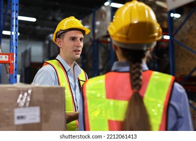 Group Of Warehouse Workers With Hardhats And Reflective Jackets Using Tablet, Walkie Talkie Radio And Cardboard While Controlling Stock And Inventory In Retail Warehouse Logistics, Distribution Center