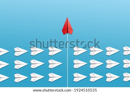 Group of white paper planes fly in a circle and one red paper plane pointing in different way on blue background. Business for new ideas creativity, innovative and solution concept.