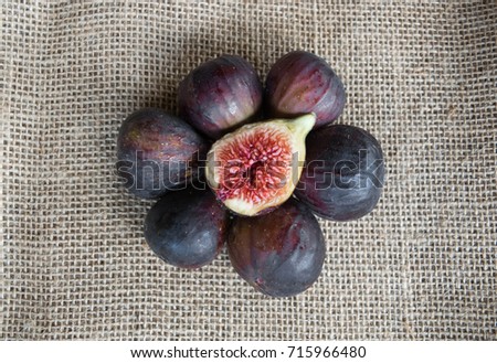 Group of whole figs in circle and one slice in the middle, sackcloth background, copy space, horizontal