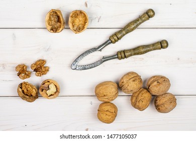 Group Of Lot Of Whole One Half Two Pieces Of Ripe Brown Walnut With Old Nutcracker Flatlay On White Wood