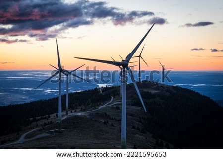 A group of wind mills early in the morning while sunrise in Austria