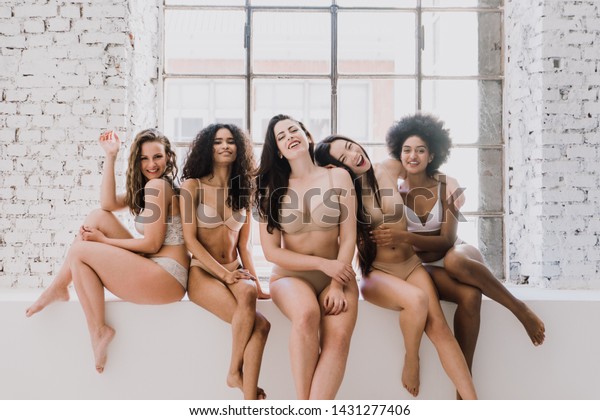 Group of women with different body and ethnicity\
posing together to show the woman power and strength. Curvy and\
skinny kind of female body\
concept