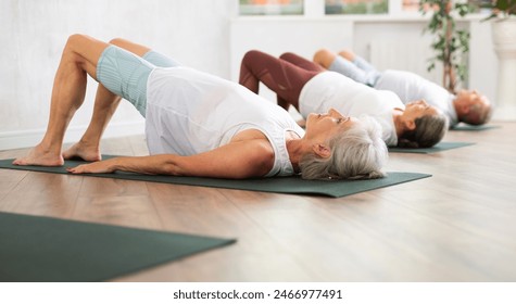 Group of women doing different yoga exercises lying on their back - Powered by Shutterstock