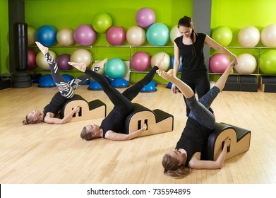 Group of women doing exercises on small barrel in the gym. Pilates, fitness, sport, training concept - Powered by Shutterstock