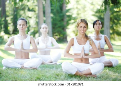 Group Of Women Doing Yoga At Park