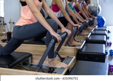 Group of women exercising on reformer in gym