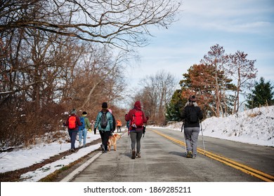 A Group Of Women Hiking On A Paved Road After A Snowfall. The View From Orange Hiking Trail Around The Gold Course In North Park, Allegheny County, Near Pittsburgh, Pennsylvania, USA