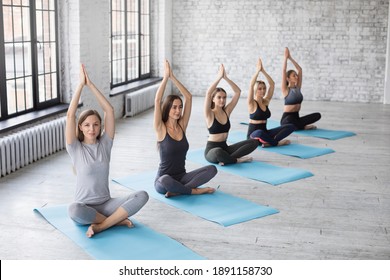 Group of women meditating at yoga studio. Concept of relaxation and meditation.