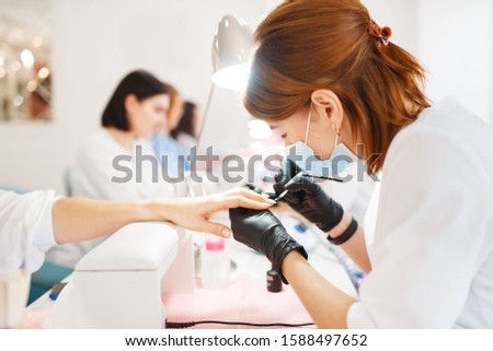 Group of women on manicure procedure, beauty salon