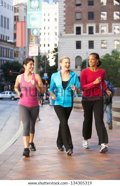 Group Of Women\
Power Walking On Urban\
Street
