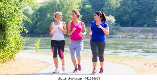 Group Of Women Running At Lakeside Jogging