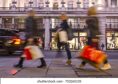 Group Of  Women Shoppers Carrying Many Shopping Bags On City Street