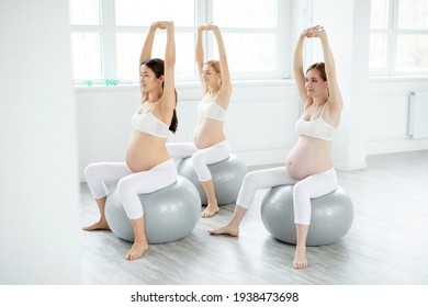 group of women in sportswear doing pregnant exercises sitting on fitness sword - Powered by Shutterstock