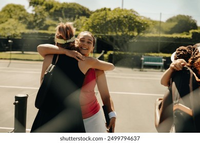 Group of women tennis players hugging and celebrating on the tennis court, expressing friendship and joy after a game - Powered by Shutterstock