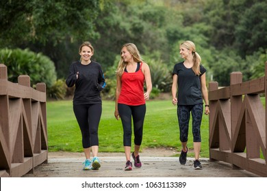 Group of women in their 30s walking together in the outdoors. Cute blond and fit women in their mid 30s who are active and working to stay healthy. Full length photo with copy space - Shutterstock ID 1063113389