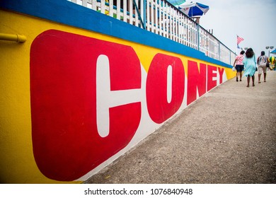 A group of women walk along the Coney Island sign at Coney Island NYC