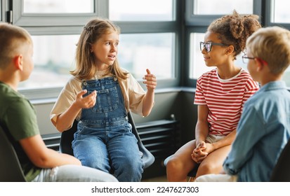 Group work of school children, multiracial students pupils discuss a collective project at school - Powered by Shutterstock