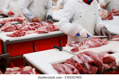 A Group Of Worker In Meat Factory, Chopped A Fresh Beef Meat In Pieces On Metal Work Table, Industry Of Processing Food.