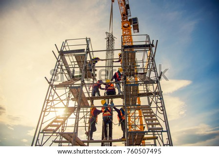 group of worker in safety uniform install reinforced steel column in construction site during sunset time
