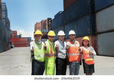 Group of worker team with helmet and safety vest stand in line and give thumbs up at logistic shipping container yard. Woman and men workmate engineers working together at workplace. - Powered by Shutterstock