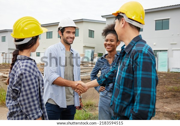 group of workers or architect shaking hands together\
at construction site