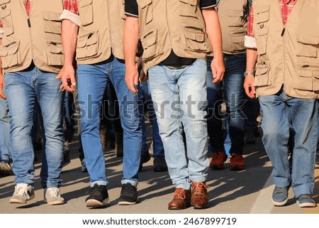 group of workers in brown vests walking during a strike participating in a protest demonstration in the city