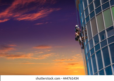 Group Of Workers Cleaning Windows Service On High Rise Building. Work On The Heights , Industrial Mountaineering