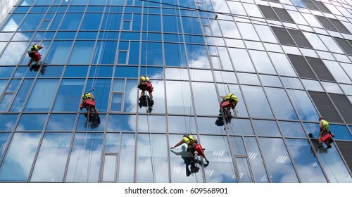 Group Of Workers Cleaning Windows Service Of Modern Office Building