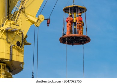 A Group Of Workers Consist Of Riggers And Engineers Riding A Personal Transfer Basket, Transferring From A Tug Boat To Heavy Lift Pipelay Barge At Offshore Oil Field