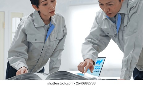 A group of workers discussing something while looking at a catalogue