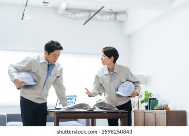 A group of workers discussing while looking at a manual
