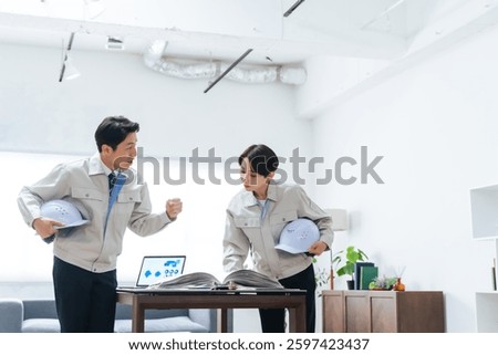 A group of workers discussing while looking at a manual