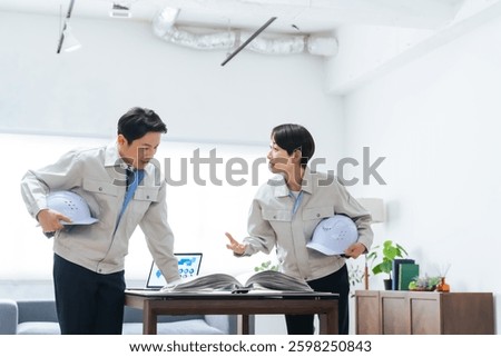 A group of workers discussing while looking at a manual