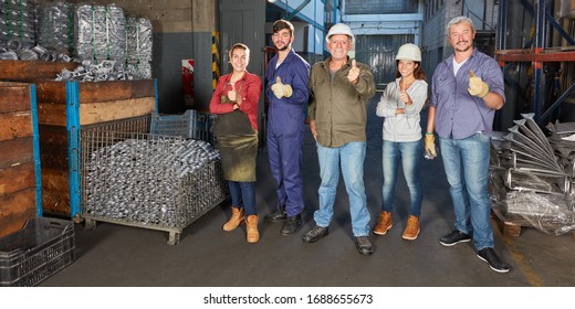 Group of workers in a metalworking factory holding their thumbs up - Shutterstock ID 1688655673