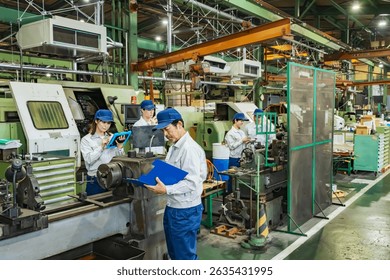 A group of workers operating machine tools in a factory